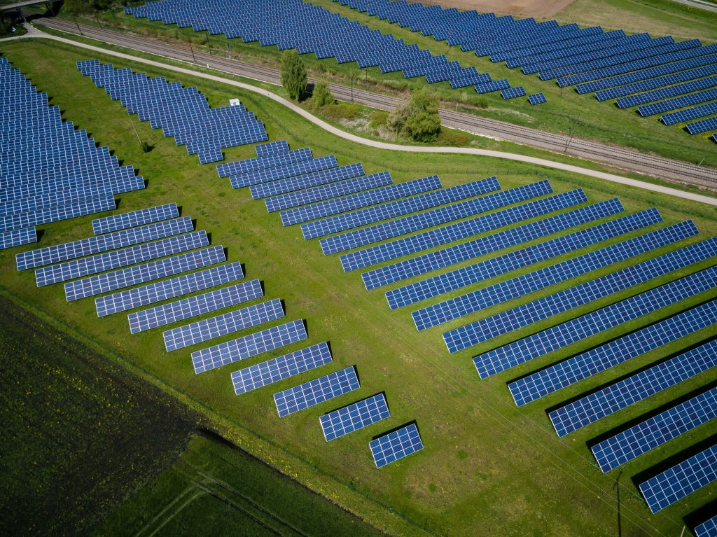 Several solar panels laid out on an open field to harvest solar energy